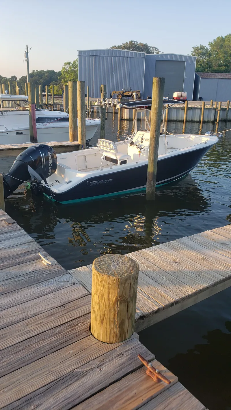 Slide: The Image of 2009 Triton 225 CC boat docked at marina. - 6