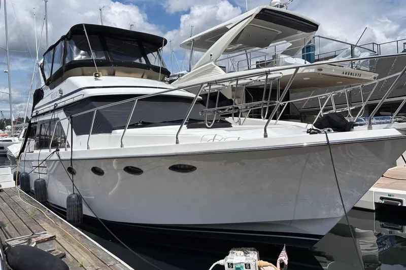 Slide: The Image of 1990 Ocean Alexander 420 Sport Sedan yacht docked at marina under cloudy sky. - 2