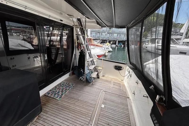 Slide: The Image of 1990 Ocean Alexander 420 Sport Sedan yacht interior with wooden deck and marina view. - 3