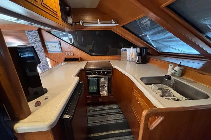 Slide: The Image of 1990 Ocean Alexander 420 Sport Sedan yacht kitchen with wood cabinetry and modern appliances. - 6