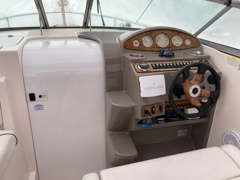 Slide: The Image of 2007 Rinker 280 Express Cruiser helm with wood steering wheel. - 28