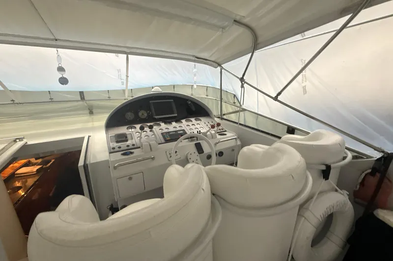 Slide: The Image of Cockpit of a 1999 Diaship 53 yacht with white seating and navigation controls. - 25