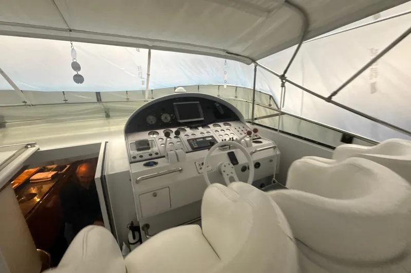 Slide: The Image of Cockpit of a 1999 Diaship 53 yacht with white seating and control panel. - 26