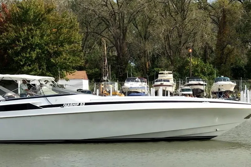 Slide: The Image of 1999 Diaship 53 boat docked near marina with trees in background. - 3
