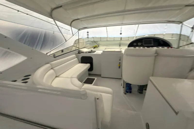 Slide: The Image of Interior of a 1999 Diaship 53 yacht with white seating and helm. - 44