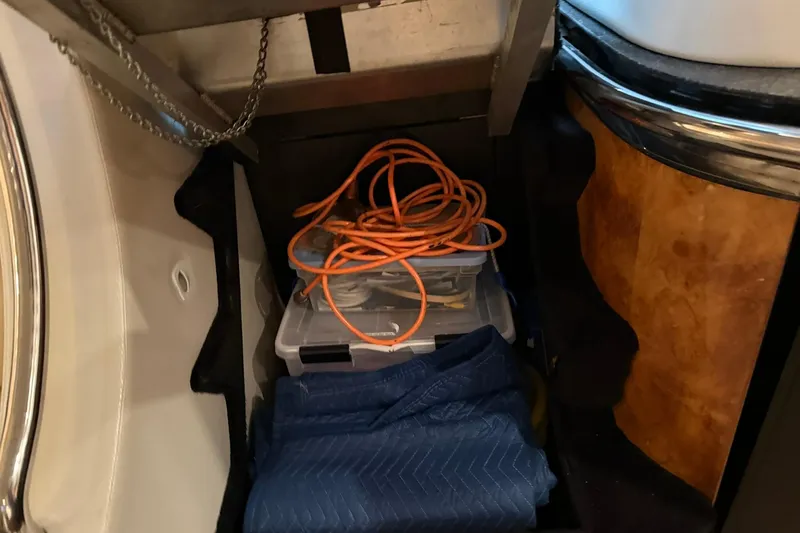 Slide: The Image of Storage area in a 1999 Diaship 53 with cables and a plastic container. - 45