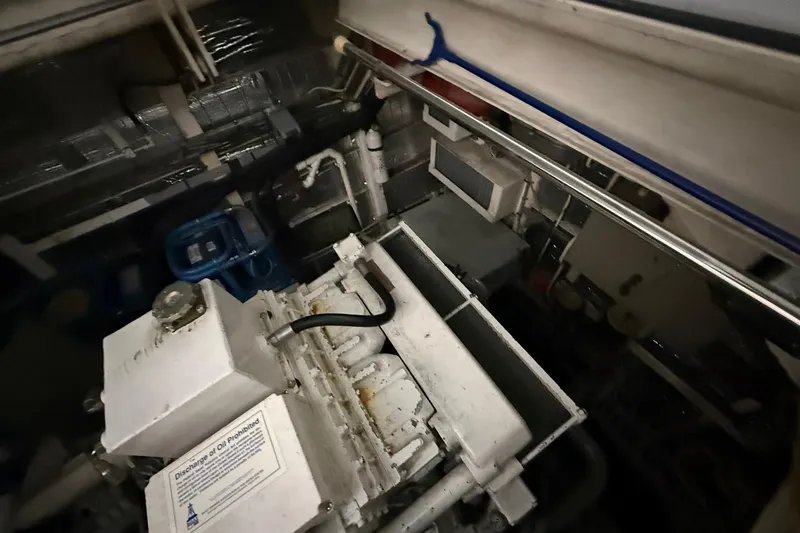Slide: The Image of Engine room of a 1999 Diaship 53 yacht, featuring machinery and piping. - 54
