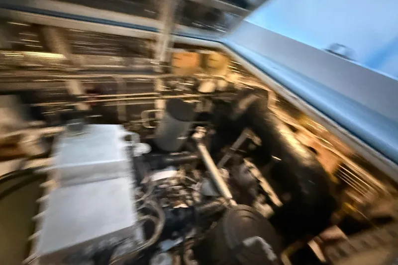 Slide: The Image of Blurry engine room of a 1999 Diaship 53 yacht, showcasing mechanical components. - 61