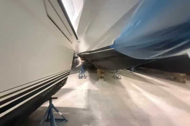 Slide: The Image of Boats in storage, including a 1999 Diaship 53, supported by stands and blocks. - 68