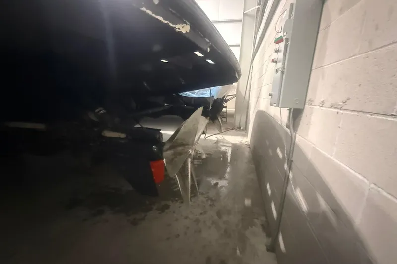 Slide: The Image of 1999 Diaship 53 boat in storage, showing propeller and rudder in a dimly lit garage. - 75