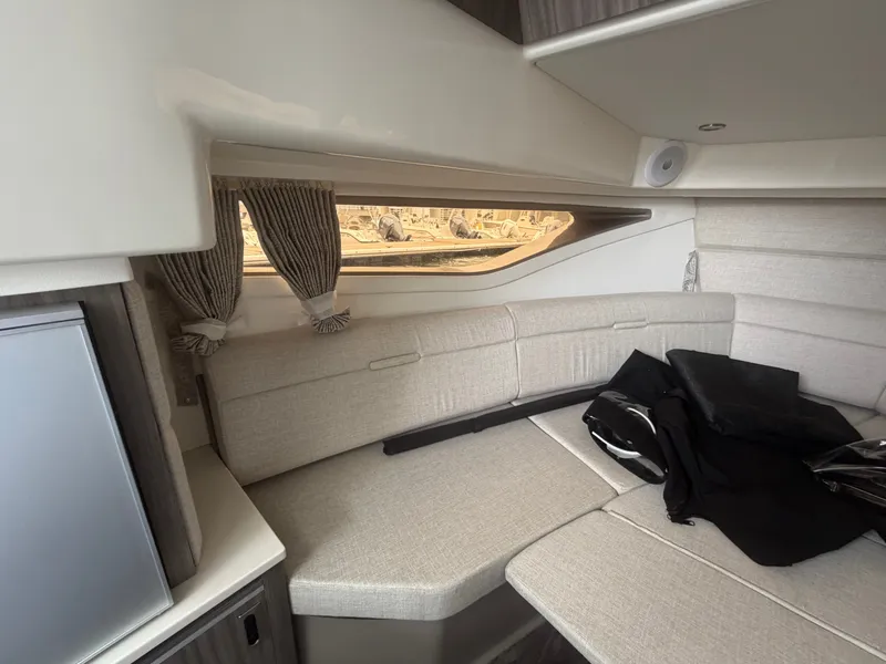 Slide: The Image of Interior of a Sea Ray Sundancer 320 Outboard with beige sofa and window with curtains. - 33