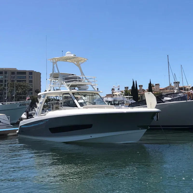 Slide: The Image of 2018 Boston Whaler 420 Outrage boat docked in a marina on a sunny day. - 2