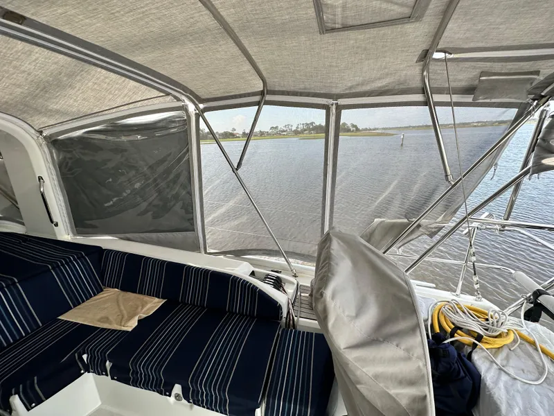Slide: The Image of Interior view of 2023 Beneteau Oceanis 46.1 sailboat with striped seating and water backdrop. - 21