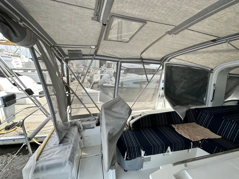 Slide: The Image of Interior view of 2023 Beneteau Oceanis 46.1 yacht with covered seating area at marina. - 22