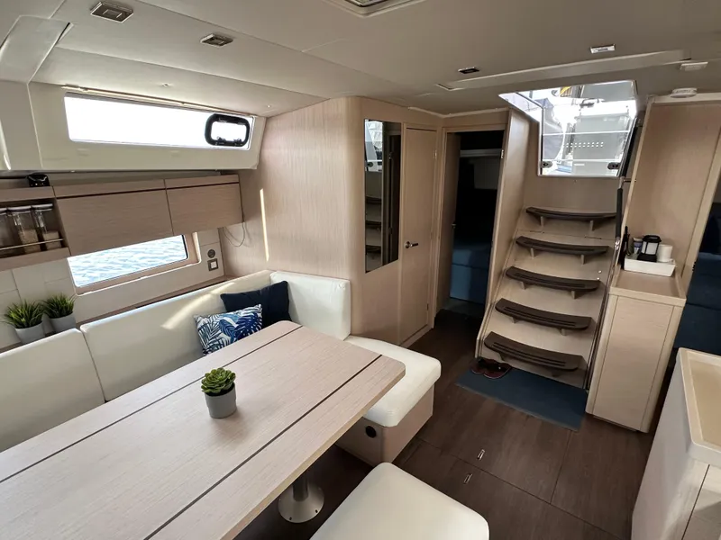 Slide: The Image of Interior of 2023 Beneteau Oceanis 46.1 yacht, featuring modern dining area and elegant staircase. - 36
