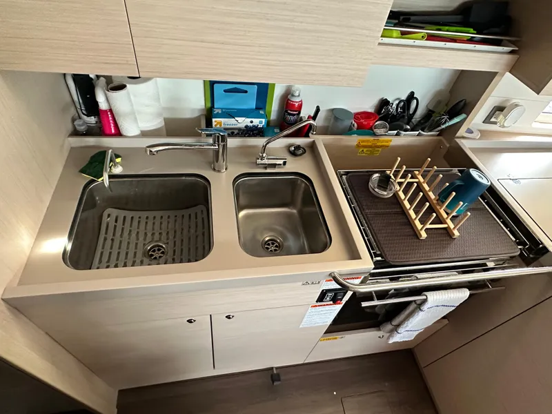 Slide: The Image of Modern kitchen in 2023 Beneteau Oceanis 46.1 yacht with dual sinks and organized storage. - 48