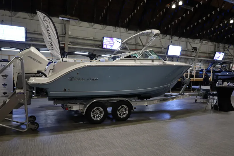 Slide: The Image of 2026 Sailfish 236 DC boat displayed indoors on a trailer. - 1
