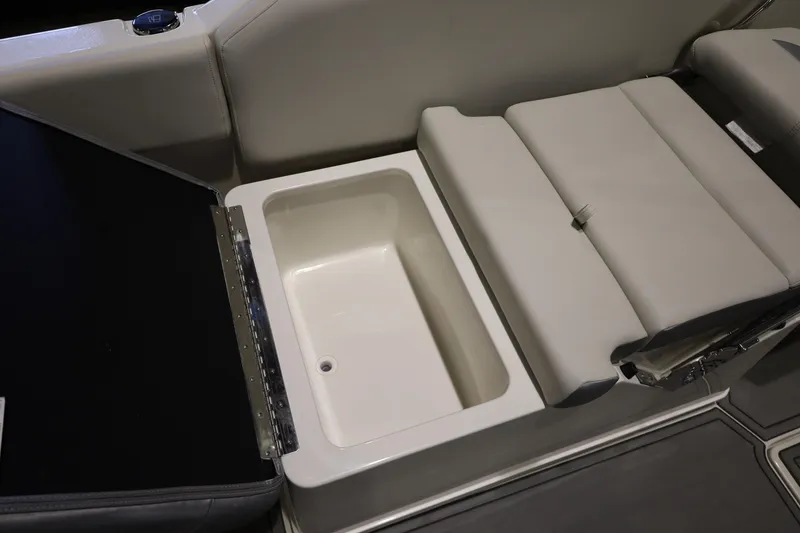Slide: The Image of Sailfish 236 DC 2026 boat interior with cushioned seating and built-in storage compartment. - 12