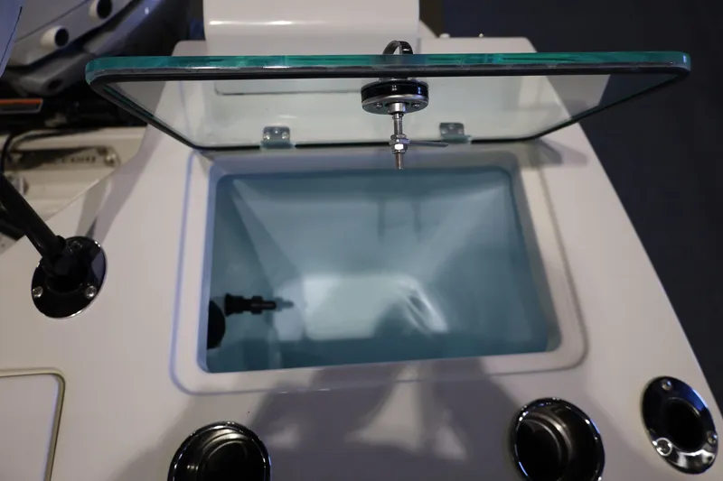 Slide: The Image of Livewell compartment on 2026 Sailfish 236 DC boat, featuring a glass lid and sleek design. - 15