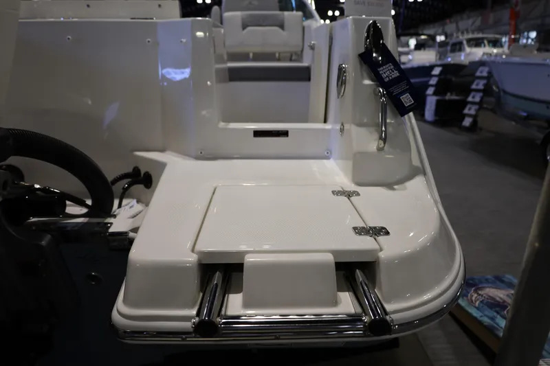 Slide: The Image of 2026 Sailfish 236 DC boat deck with swim platform and ladder at a showroom. - 18