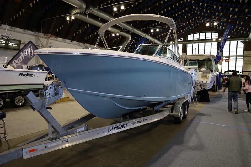 Slide: The Image of 2026 Sailfish 236 DC boat on trailer in indoor showroom. - 2