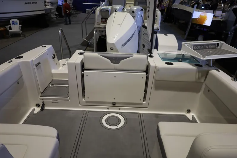 Slide: The Image of 2026 Sailfish 236 DC boat interior with seating and Mercury engine at a boat show. - 35