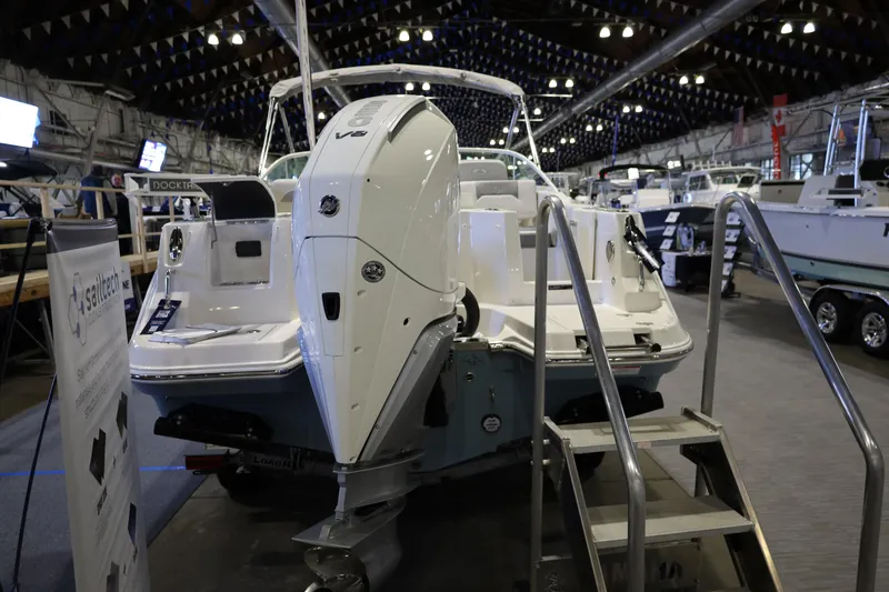 Slide: The Image of 2026 Sailfish 236 DC boat displayed indoors with powerful V8 engine. - 5