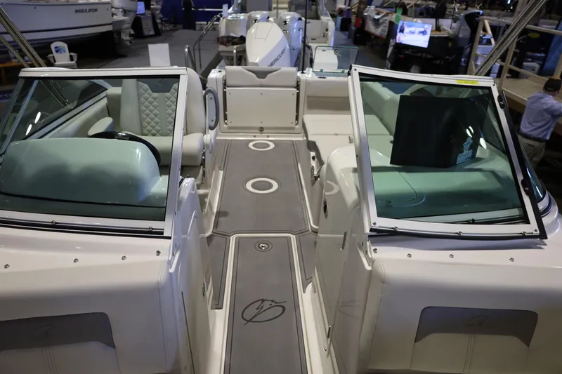 Slide: The Image of 2026 Sailfish 236 DC boat interior with dual consoles and seating at a boat show. - 6