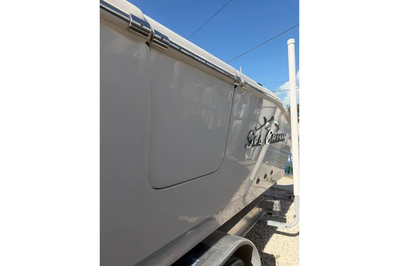 Slide: The Image of 2023 Sea Chaser 27 HFC CC boat side view with logo under clear blue sky. - 24