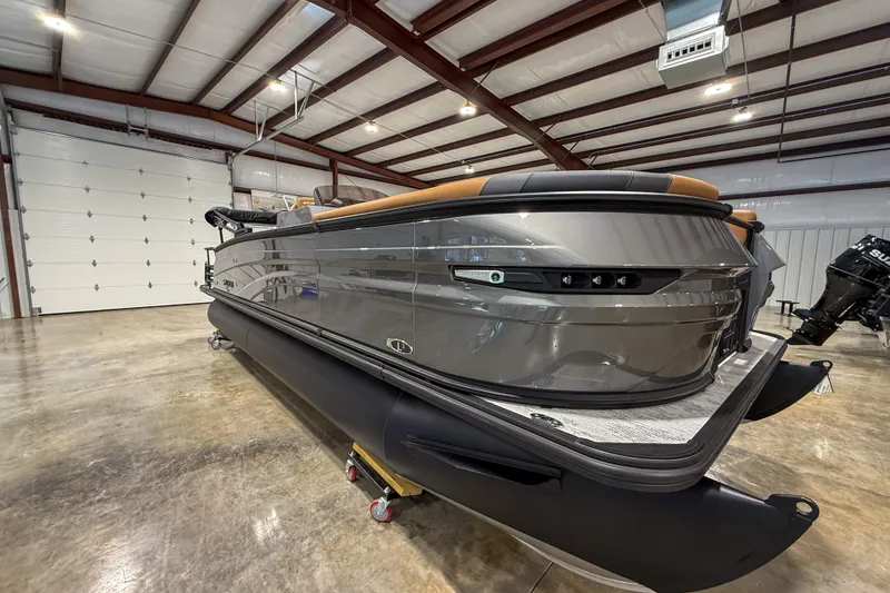 Slide: The Image of 2026 Sylvan L3 LZ DH pontoon boat in a spacious indoor showroom. - 2
