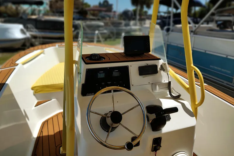 Slide: The Image of 2004 Angler 204 Center Console boat interior with steering wheel and navigation equipment. - 9