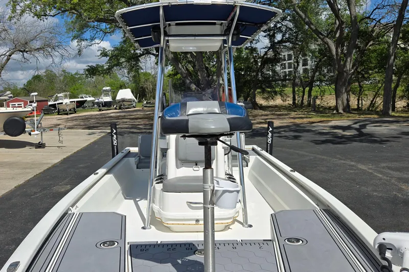 Slide: The Image of 2021 Avid 23 FS boat with T-top and seating, parked outdoors. - 11