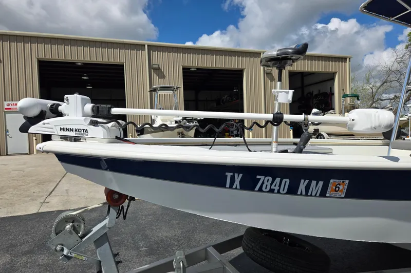 Slide: The Image of 2021 Avid 23 FS boat with Minn Kota Terrova motor, parked outside a warehouse. - 20