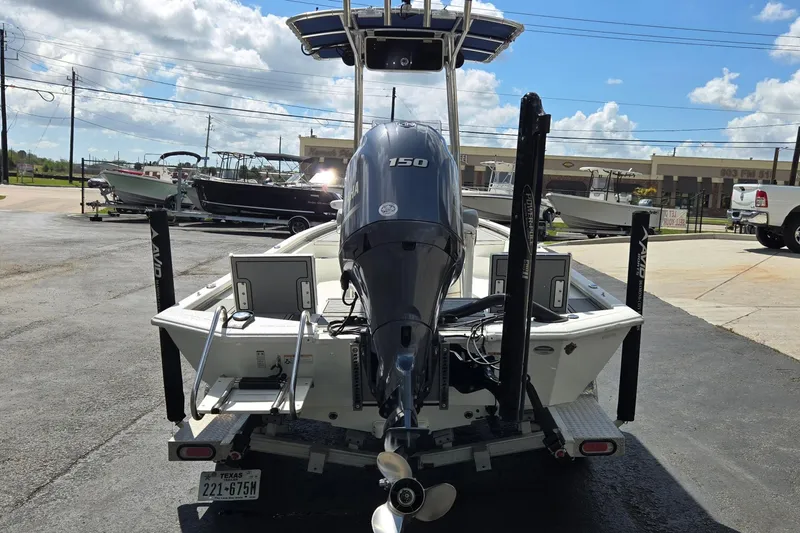 Slide: The Image of 2021 Avid 23 FS boat with Yamaha 150 engine, parked outdoors under a sunny sky. - 4