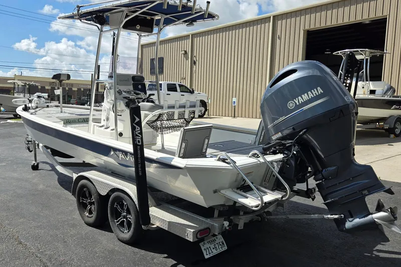 Slide: The Image of Avid 23 FS 2021 boat with Yamaha motor on trailer, parked outside a warehouse. - 5