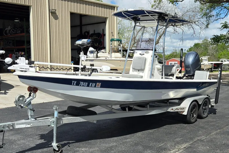 Slide: The Image of 2021 Avid 23 FS boat on trailer, parked outside a storage facility. - 7