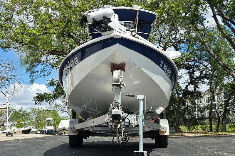 Slide: The Image of 2021 Avid 23 FS boat on trailer, surrounded by trees and clear sky. - 9