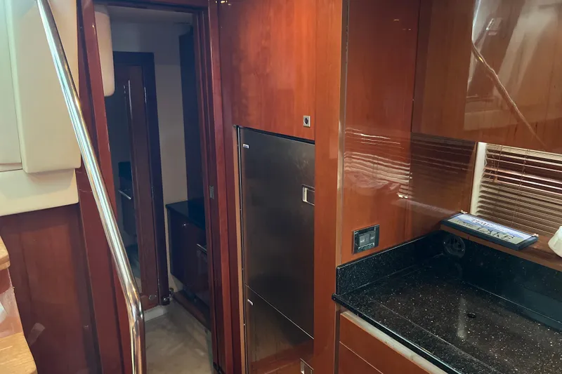 Slide: The Image of Interior of 2009 Searay 470 Sundancer yacht with wood paneling and modern kitchen amenities. - 18