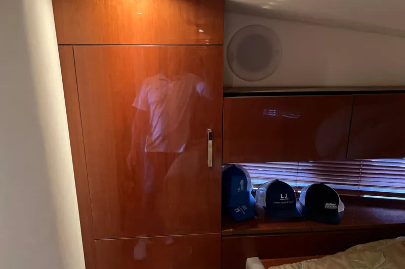 Slide: The Image of Interior of 2009 Searay 470 Sundancer with wooden cabinetry and hats on a shelf. - 26