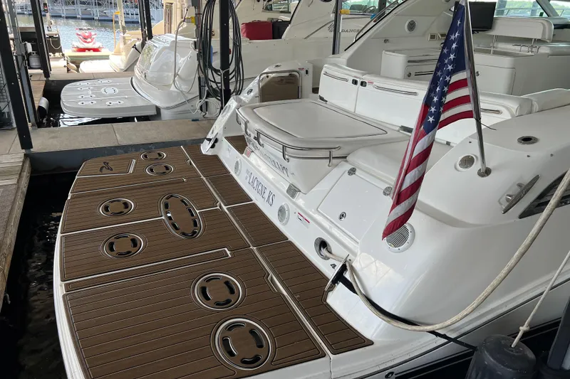 Slide: The Image of 2009 Searay 470 Sundancer yacht docked, featuring a wooden deck and American flag. - 3
