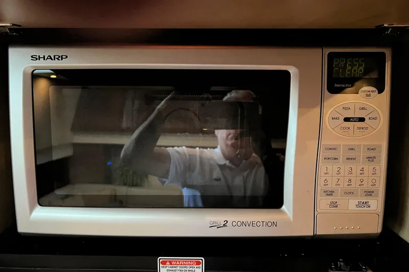 Slide: The Image of Sharp microwave oven with convection and grill features, reflecting a person taking a photo. - 30