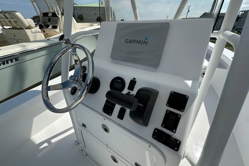 Slide: The Image of Boat console with Garmin navigation, steering wheel, and controls on a 2018 Intruder 23 model. - 10