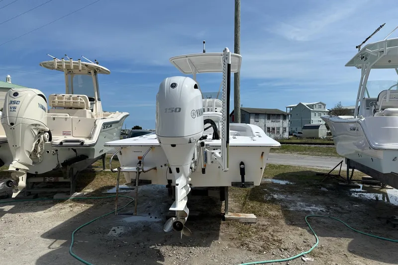 Slide: The Image of 2018 Intruder 23 boat with Yamaha 150 engine, displayed outdoors between two other boats. - 3