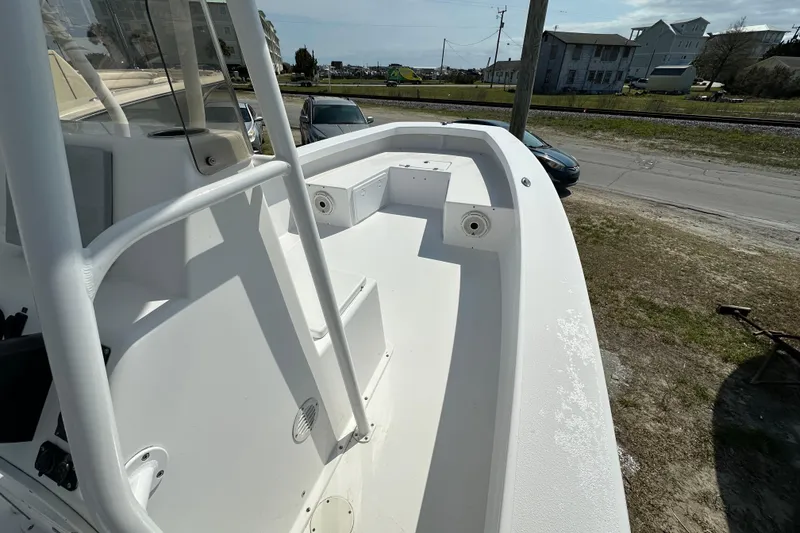 Slide: The Image of 2018 Intruder 23 boat deck, white interior, parked outdoors near road and buildings. - 7
