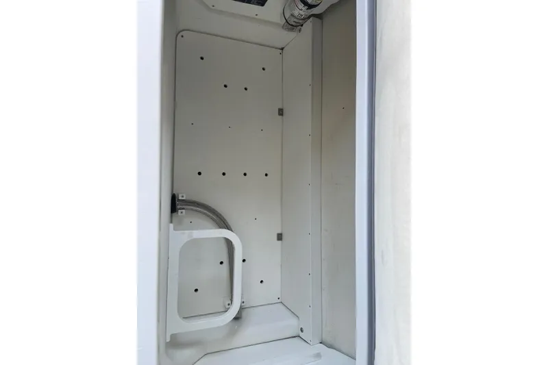 Slide: The Image of Storage compartment of a 2022 Cobalt R8 Outboard boat, featuring a drain plug. - 16
