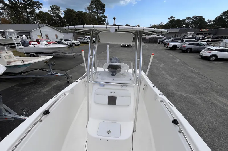 Slide: The Image of 2012 Tidewater 216 CC Adventure boat in a dealership lot, surrounded by vehicles. - 12