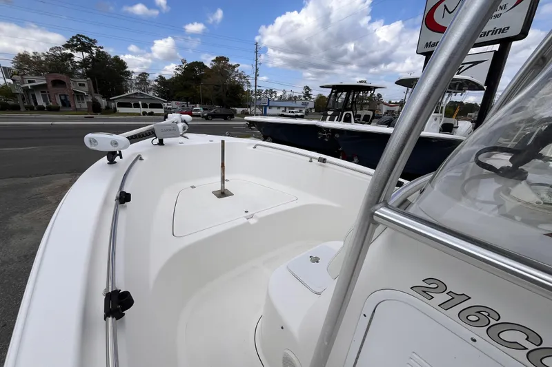Slide: The Image of 2012 Tidewater 216 CC Adventure boat with Garmin equipment, parked outdoors under a cloudy sky. - 13