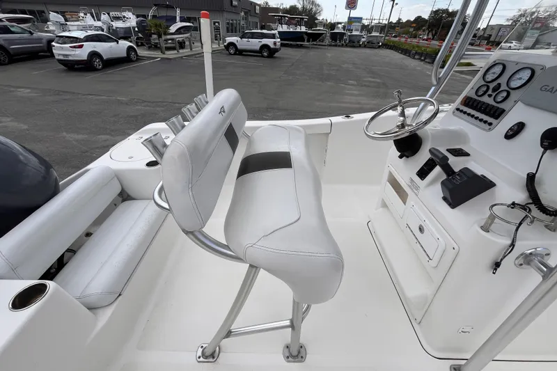 Slide: The Image of 2012 Tidewater 216 CC Adventure boat interior with helm and seating area. - 7