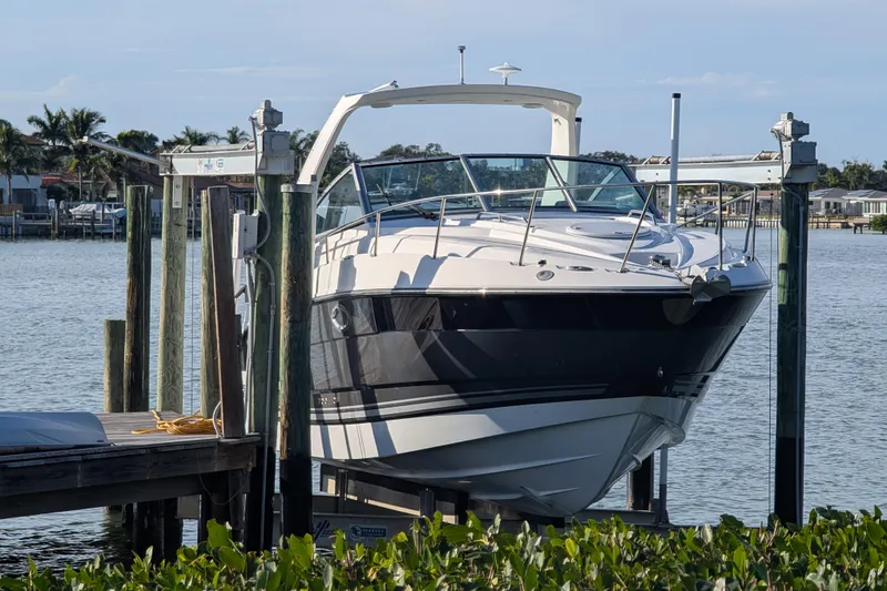 The Image of 2022 Monterey 295SS Super Sport boat docked on a lift by the water. - 1