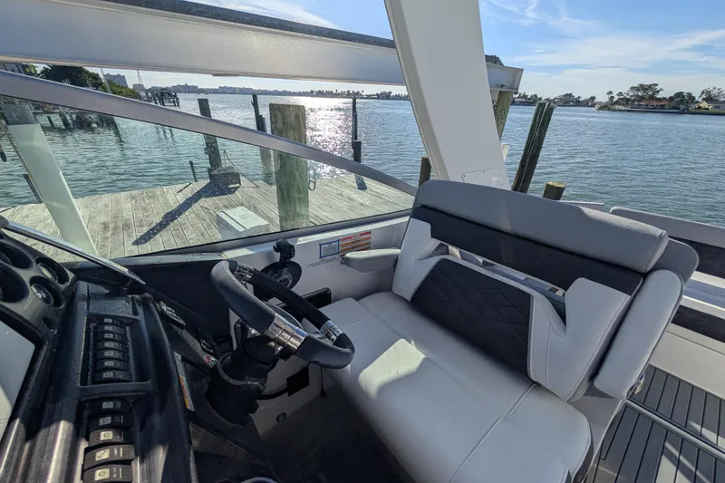 Slide: The Image of Interior view of 2022 Monterey 295SS Super Sport boat cockpit by the water. - 22